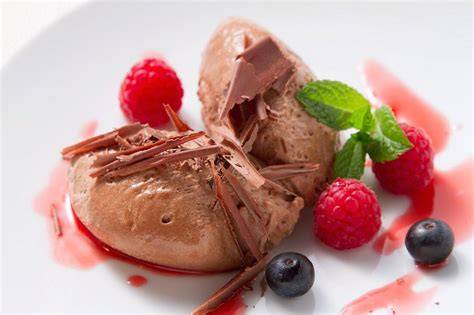 [Dekorierte Mousse au Chocolat mit Beeren, Minze und Schokoraspeln]