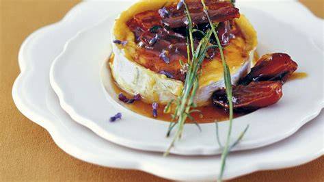 Überbackener Ziegenkäse mit Honig und Pinienkernen - appetitliche Nahaufnahme