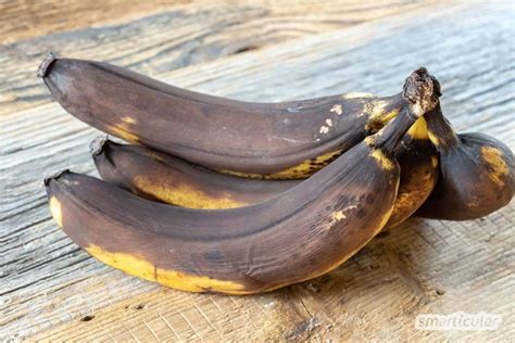 Überreife Bananen mit braunen Flecken neben veganer Zartbitterschokolade und Kakaopulver