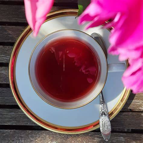 Ahornsirup-Flasche und Agavendicksaft-Löffel neben einer Teetasse