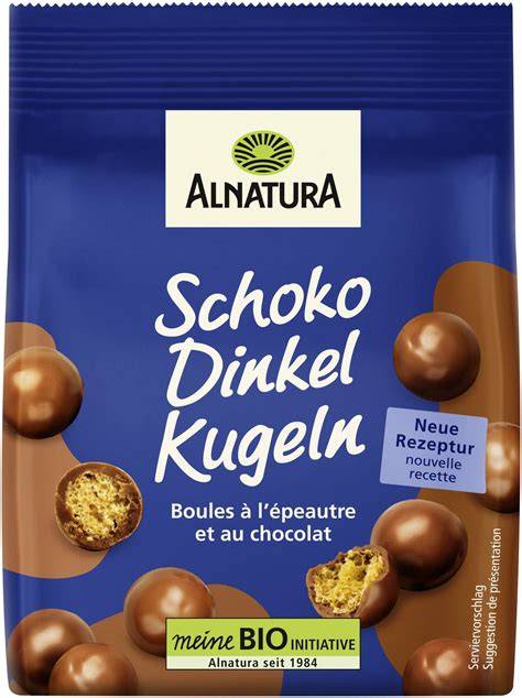 Alnatura Schoko Dinkel Kugeln Packung und Kugeln auf Holzuntergrund