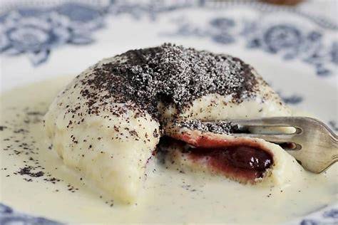 Angerichtete Germknödel mit viel Vanillesauce und Mohnzucker