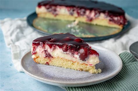Angeschnittener Kirschkuchen mit Sahne garniert