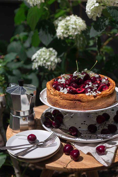 Angeschnittenes Stück Allgäuer Käsekuchen mit frischen Kirschen