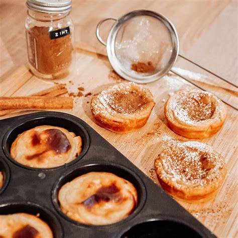 Anrichten: Pastéis de Nata mit Zimt und Puderzucker