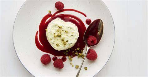 Anrichten der gefüllten Meringue-Kugeln mit Himbeercoulis und Spekulatius