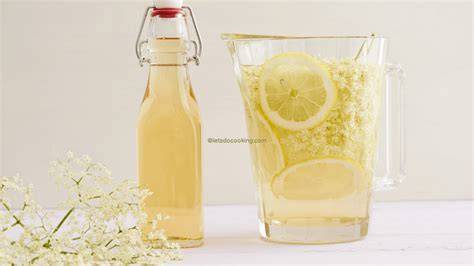 Ansatz für Holunderblüten-Sirup im Glasgefäß mit Zitronenscheiben