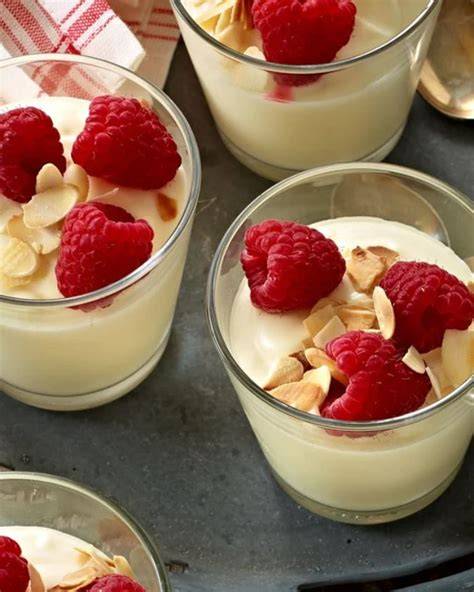 Anschnitt: helle Biskuitlagen, weiße Mousse, Himbeeren