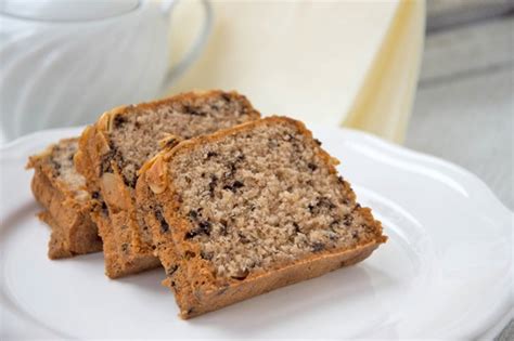 Anschnitt Tiroler Nusskuchen mit Nougat und Schoko-Glasur, Kaffeetassen und Sahne