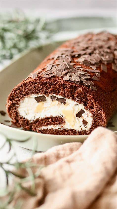 Anschnitt der fertigen Kirschen-Mascarpone-Biskuitrolle mit Sahne und Schokoraspeln