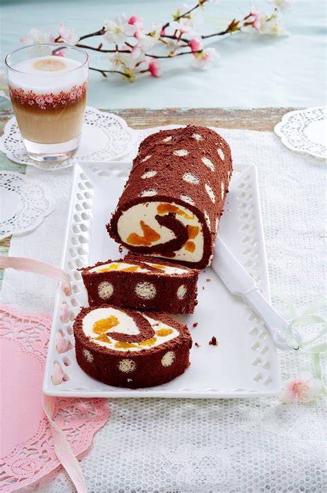 Anschnitt einer Biskuitrolle, dekoriert mit Buttercreme und Schokolade