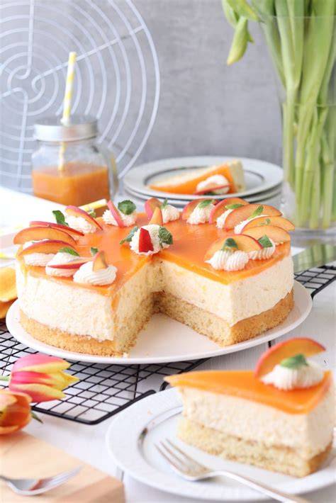 Anschnitt einer Eierlikör-Pfirsich-Torte mit Pfirsichspiegel und Sahnetuffs