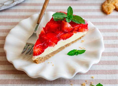 Anschnitt einer Erdbeer-Frischkäse-Torte ohne Backen mit Keksboden und glänzendem Tortenguss