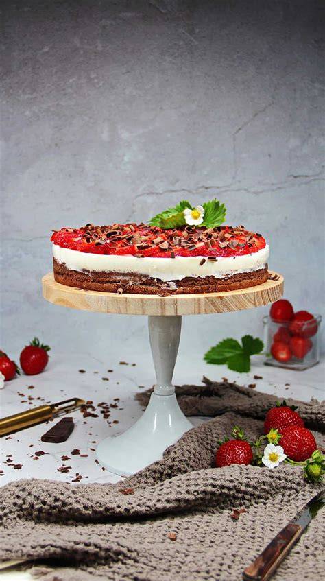 Anschnitt einer Erdbeer-Schoko-Torte mit Drips und frischen Erdbeeren