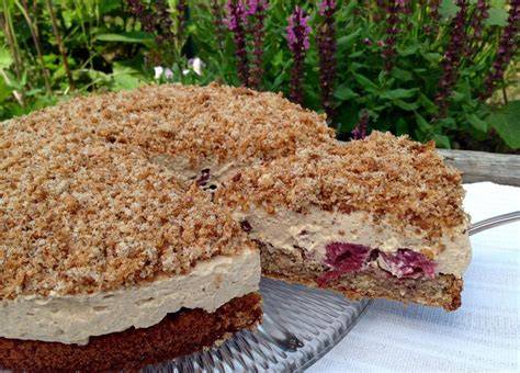 Anschnitt einer Espresso Nuss Torte mit Sahnekunst und Kirschen