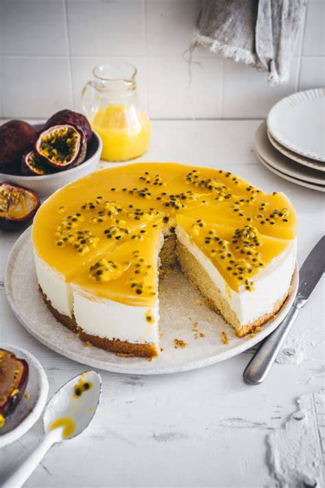 Anschnitt einer Maracuja Torte mit frischen Maracujas und Pfirsichen dekoriert