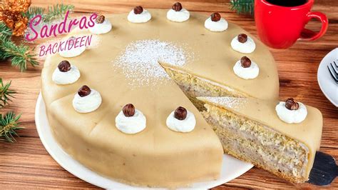 Anschnitt einer Marzipan‑Nuss‑Torte mit Sahnehäubchen