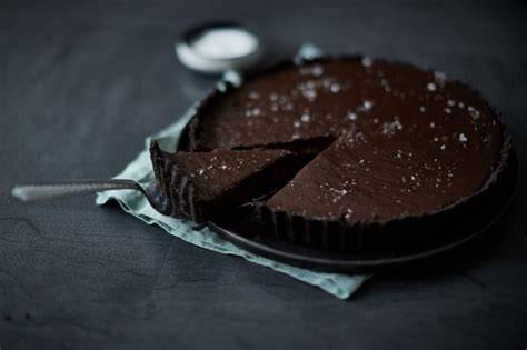 Anschnitt einer Schoko-Erdnuss-Karamell-Tarte mit Meersalz