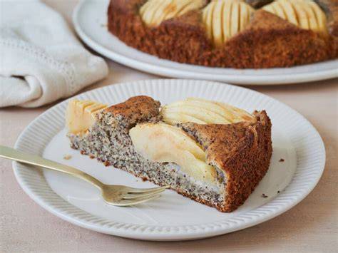 Anschnitt einer saftigen Apfel-Mohn-Torte mit sichtbaren Apfelschichten und Mohn