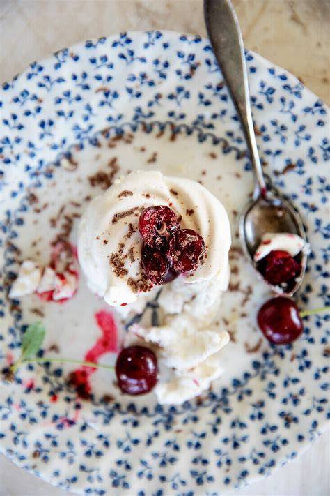 Anschnitt eines Eisbergkuchens mit Kirsch-Blätterteig-Röllchen und Schokoraspeln