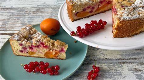 Anschnitt eines Johannisbeer-Marzipan-Orangenkuchens mit dekorierten Johannisbeeren