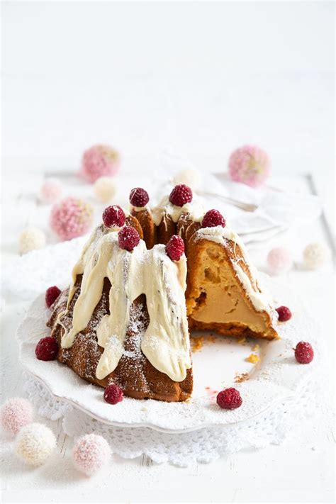 Anschnitt eines Kokos-Cheesecakes mit weißer Schokoladenglasur und Kokosflocken