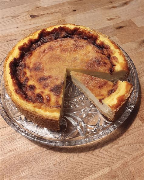 Anschnitt eines Quark-Sahne-Kuchens mit cremiger Füllung und Mürbeteigboden