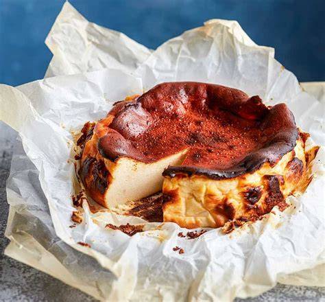 Anschnitt eines cremigen Burnt Basque Cheesecakes mit Früchten