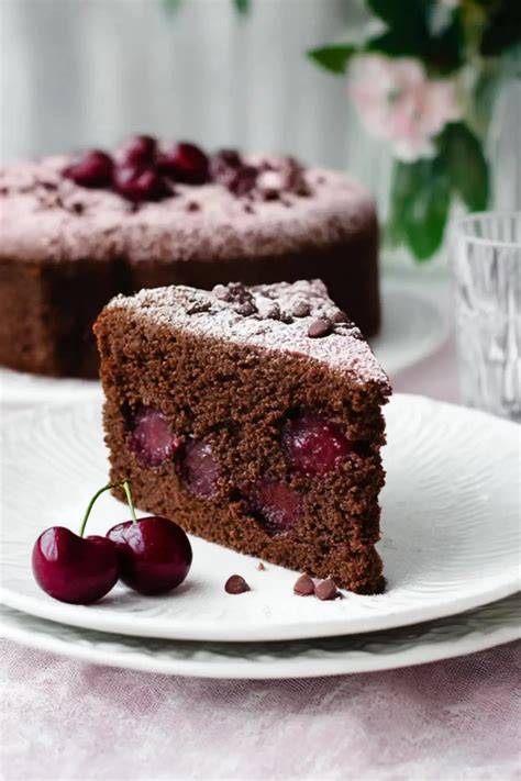 Anschnitt eines saftigen Schoko-Kirsch-Kuchens mit Kirschen und Schokostückchen