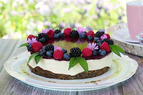 Ansicht der fertigen weißen Schokomousse-Torte mit Mohnboden und Beeren