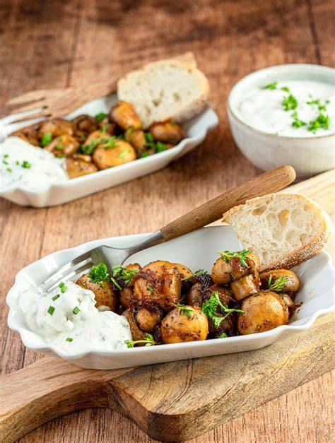 Antipasti-Teller mit marinierten Champignons, Fladenbrot und Kräuterdip