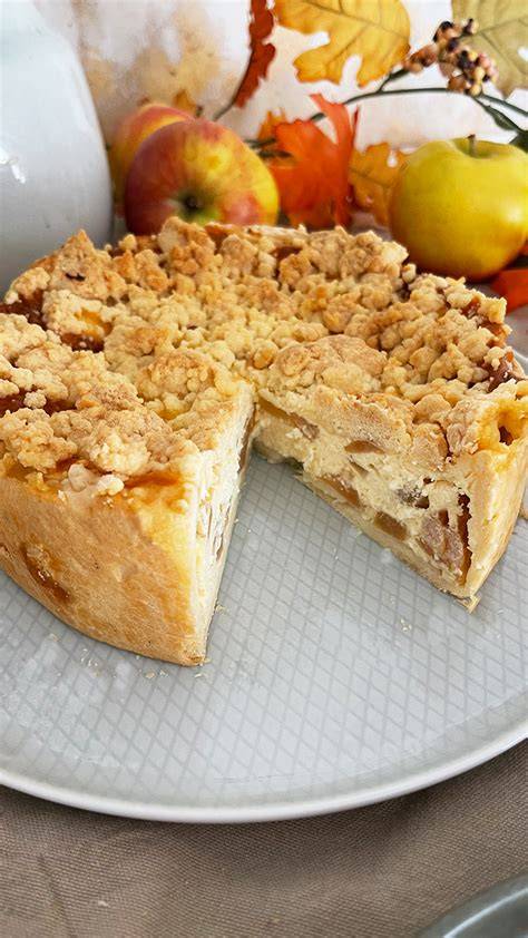 Apfel Käsekuchen mit Baiserhaube auf einem rustikalen Teller