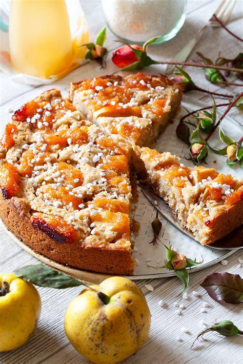 Apfel Quitten Kuchen scheibe auf Holztisch, Äpfel und Quitten im Hintergrund