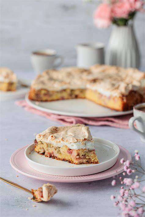 Apfel-Baiser-Kuchen vom Blech mit Zimtstreuseln, aufgeschnitten serviert auf einem Holzbrett