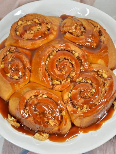Apfel-Karamell-Schnecken, serviert mit Karamellsauce und herbstlicher Deko