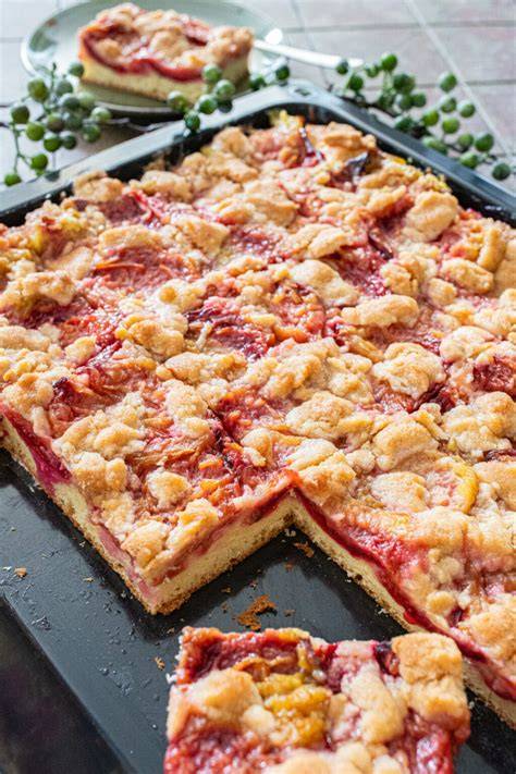 Apfel-Rhabarber-Kuchen mit Streuseln auf dem Blech, frisch gebacken und angeschnitten