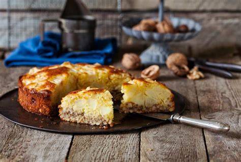 Apfel-Walnuss-Kuchen auf Kaffeetisch, angeschnitten