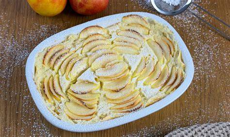 Apfelauflauf in Auflaufform mit Apfelspalten, Mandelblättchen und Vanillesoße