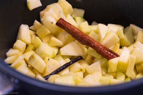 Apfelkompott in Topf mit Zimtstange