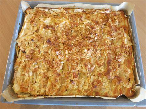 Apfelkuchen auf Holzbrett, Mandelguss sichtbar