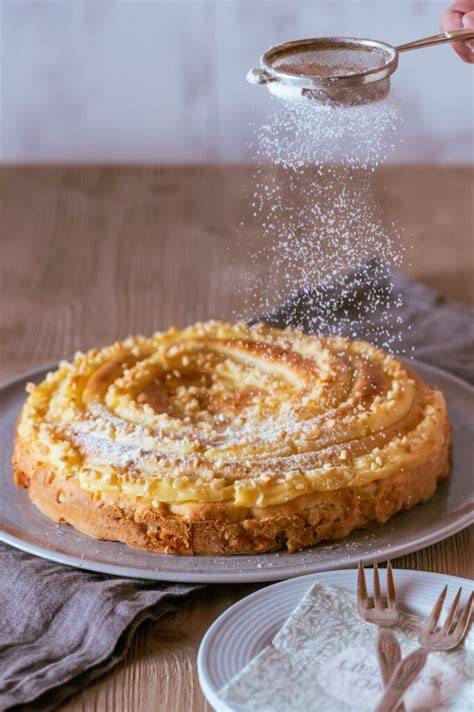 Apfelkuchen auf Kuchenplatte mit Puderzucker bestäubt