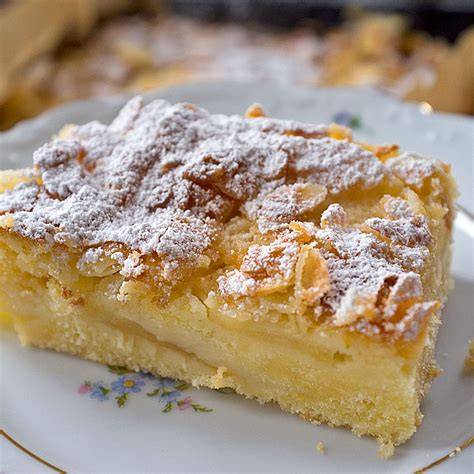 Apfelkuchen auf dem Blech mit Mandelblättchen und Puderzucker