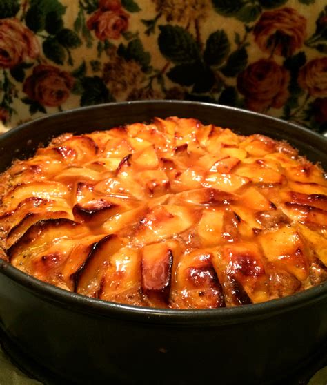 Apfelkuchen aus dem Ofen, angeschnitten, mit Walnusshälften dekoriert