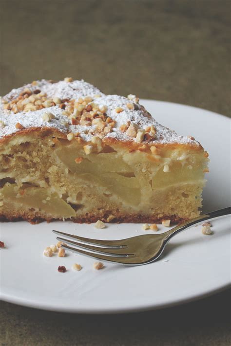 Apfelkuchen mit Crème fraîche und Mandeln auf einem Kuchenteller