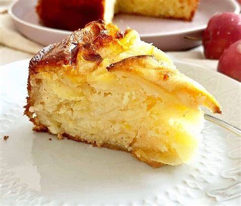 Apfelkuchen mit Joghurt und Protein in Anschnitt, auf einer rustikalen Holzplatte arrangiert