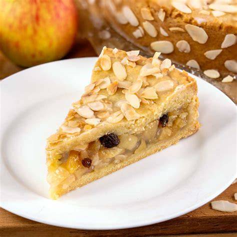 Apfelkuchen mit Mandeln und Rosinen verfeinert und in Stücke geschnitten