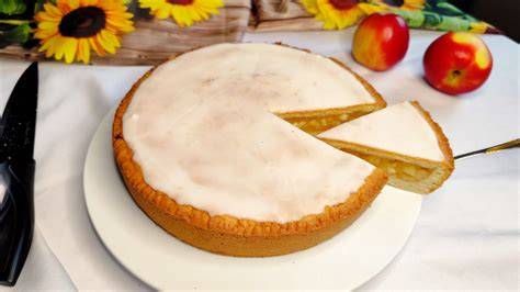 Apfelkuchen mit Sonnenblumenkernen angeschnitten auf einem Tisch mit Zutaten