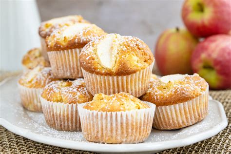 Apfelmuffins auf einem Teller mit Äpfel im Hintergrund