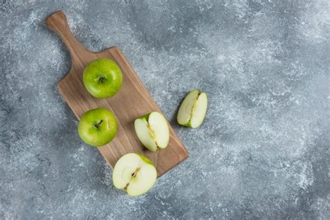Apfelmus und frische Äpfel auf Holzbrett