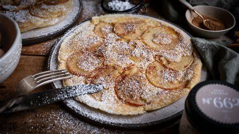 Apfelpfannkuchen auf einem Teller mit Zimt und Zucker